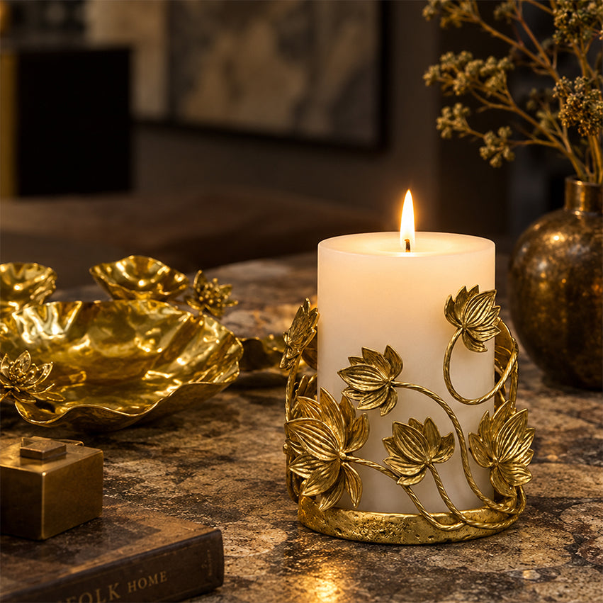 Golden Lotus Candle Holder with a lit white pillar candle on a tabletop